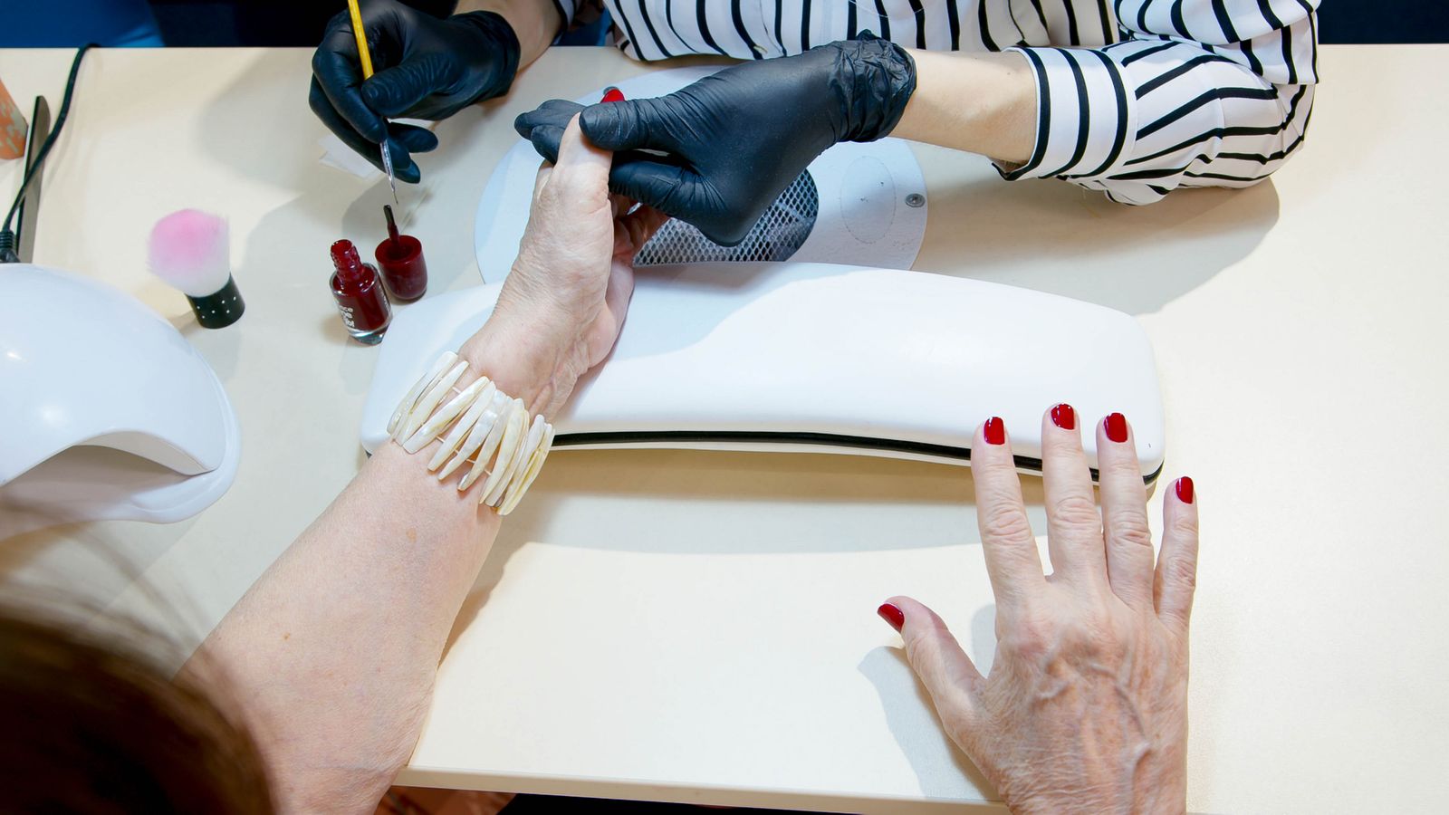 Salón de uñas atendiendo a una clienta